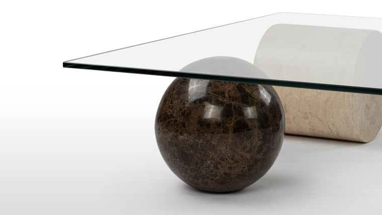 Scupltural Design | The Metafora Coffee Table is a true work of art, designed to spark conversation and ignite the imagination. Its unconventional shape creates a sense of movement and dynamism. Crafted with meticulous attention to detail, the table boasts a combination of materials, including glass, marble, and travertine, that exude a harmonious juxtaposition of strength and transparency.
