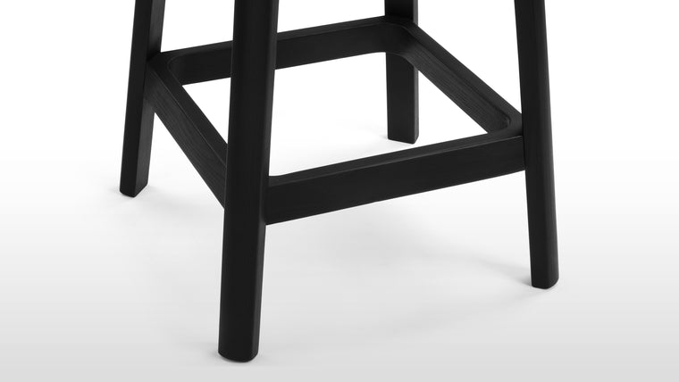Timeless Design | The stool's solid wood frame boasts clean lines and a rich finish that perfectly complements the rattan seat. The angled legs provide stability while adding a hint of architectural interest to the overall aesthetic.
