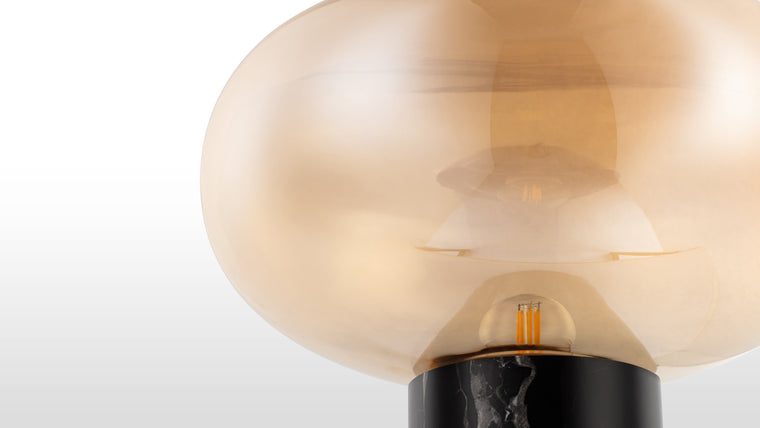 Organic Inspiration | Crafted with meticulous attention to detail, the lamp's glass curves gracefully manipulate ambient light, creating an intriguing dance of shadows and illumination. In contrast, the sturdy Black Marquina marble base adds a layer of sophistication, grounding the lamp in a subtle yet impactful way.
