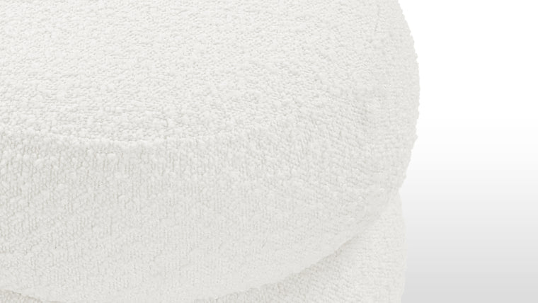 Textural Appeal | Upholstered in a boucle fabric, this ottoman offers both comfort and textural interest, its downy feeling enhancing the overall tactile experience.

