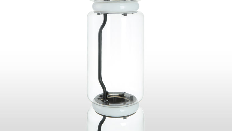 Refined Transparency | Crafted primarily from elegantly stacked glass tubes, the lamp incorporates discreet LED rings and internal wiring concealed within a shaped central structure. The open glass bowl atop the design adds an artisanal touch.
