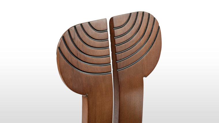 A Refined Elegance | Crafted from solid ash wood with a warm walnut stain, this chair exudes a refined elegance. The black leather upholstery offers comfort, while the curved inlay details on the backrest add a sleek, modern touch.
