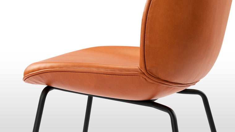 Timeless design | Upholstered in sumptuous leather, the Beetle Dining Chair offers classic comfort, everyday sophistication, and long-lasting beauty.
